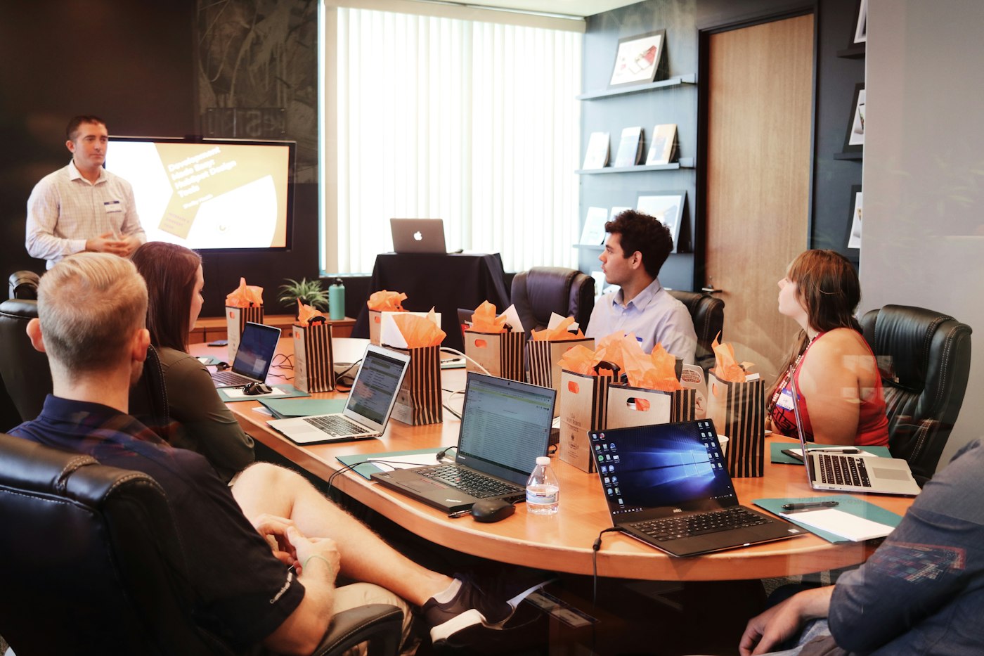 A learning and development consultant presenting to a small business team in an office